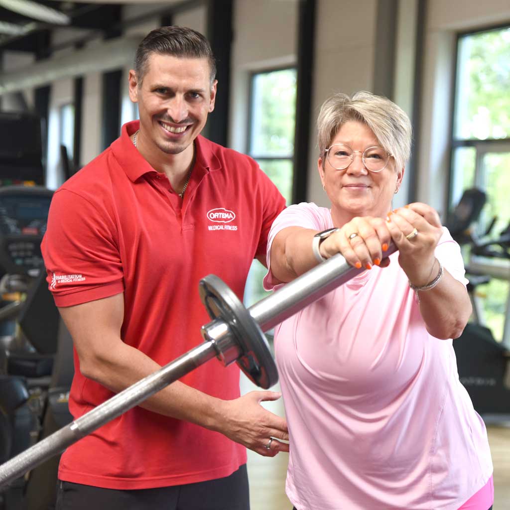 Trainer unterstützt Frau beim Training